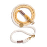 A handcrafted butterscotch-colored cotton rope dog leash with solid brass bolt snaps, coiled neatly with an individually numbered tag, designed for durability and style.