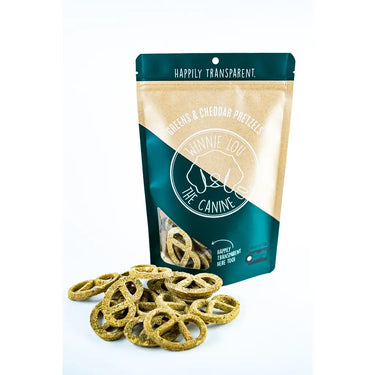 A bag of Greens & Cheddar Pretzels dog treats, showcasing their nutritious ingredients like cheddar, spinach, kale, and organic kelp.