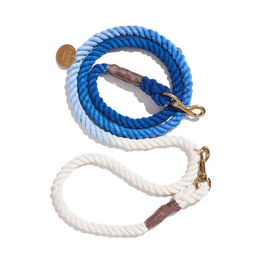 A vibrant cobalt blue cotton rope dog leash with solid brass bolt snaps, hand-spliced ends, and an individually numbered tag, designed for durability and style.
