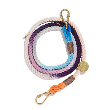"The Lois Ombre Cotton Rope Dog Leash, coiled neatly, featuring an ombre gradient design with brass hardware and an adjustable bolt snap for secure pet walking."
